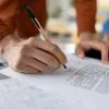Mężczyzna podpisuje druk wycofania zgody na przetwarzanie danych BIK w PKO