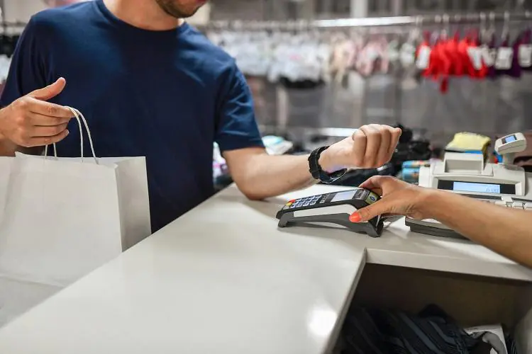 mężczyzna płacący za pomocą Google Pay za zakupy