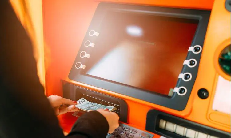 kobieta wypłacająca gotówkę z bankomatu