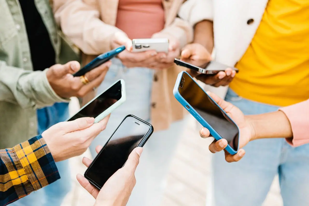 Kilka osób trzyma smartfony i wykonuje przelew na telefon BLIK