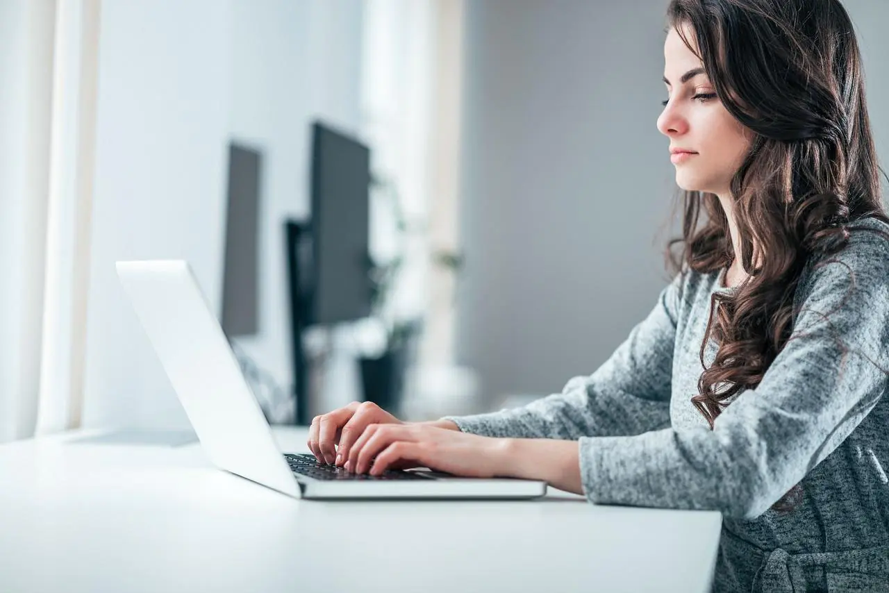 Kobieta robi przelew online za pomocą swojego laptopa