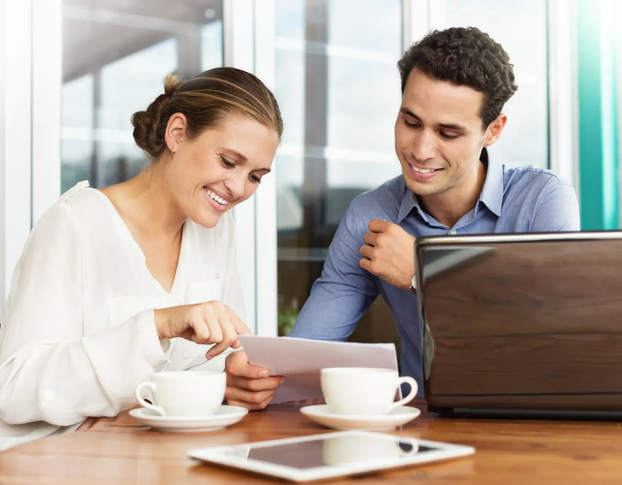 Kobieta w biurze przedstawia mężczyźnie możliwość uzyskania kredytu obrotowego