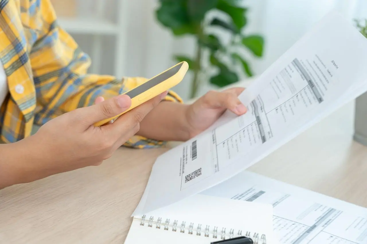 Mężczyzna sprawdza wyciąg rozliczeń transakcji na karcie kredytowej