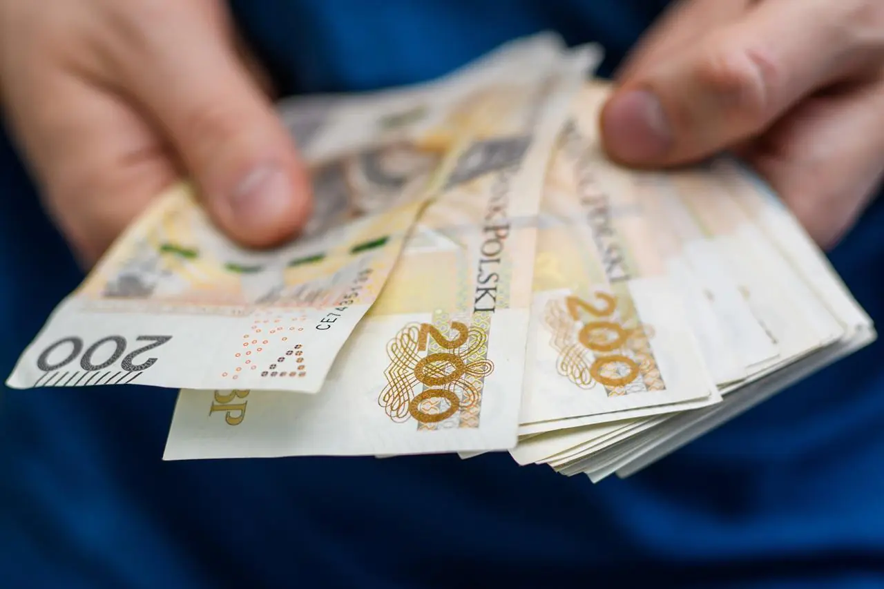Mężczyzna liczy pieniądze, które może zaoszczędzić wybierają raty równe - annuitetowe lub malejące przy kredycie hipotecznym