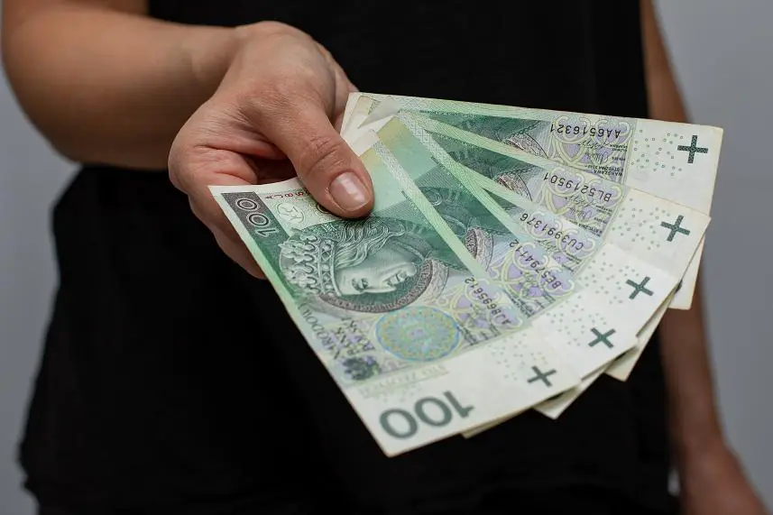 kobieta z wachlarzem ze stuzłotowych banknotów