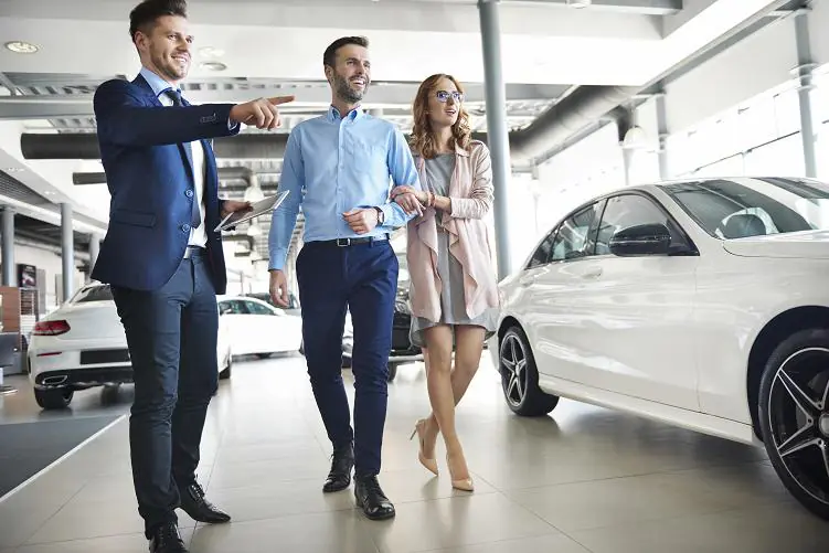 para kupująca auto w salonie w towarzystwie doradcy