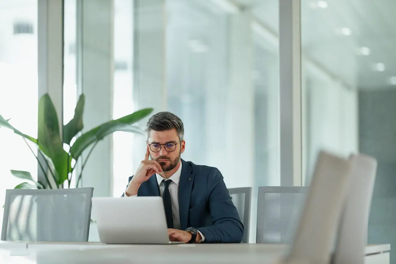 Biznesmen w biurze sprawdzający w laptopie rejestr ERIF.