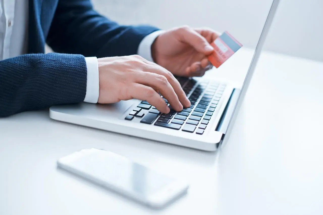 Mężczyzna aktywuje kartę Banku Millennium przez bankowość internetową