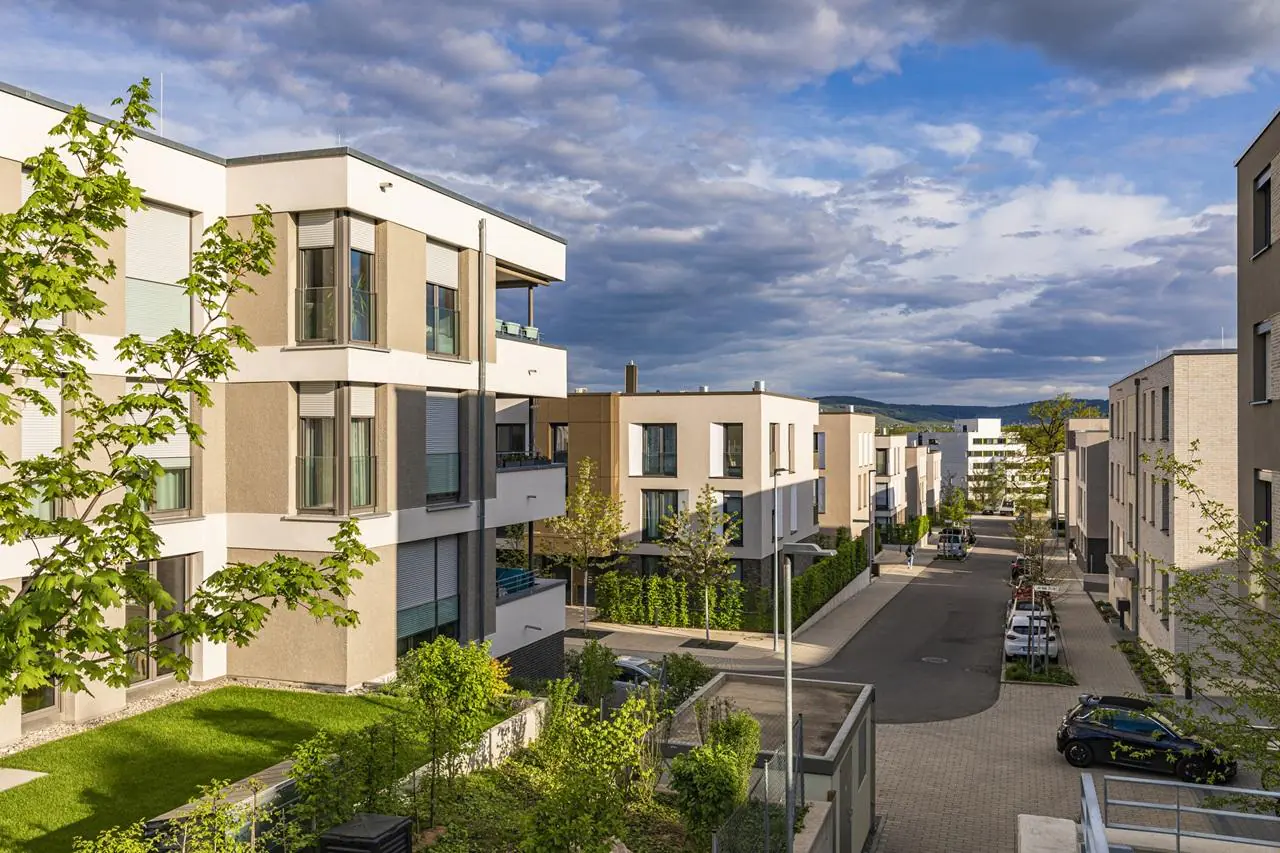 Osiedle mieszkaniowe wynajmowane w ramach TBS na tle zachmurzonego nieba