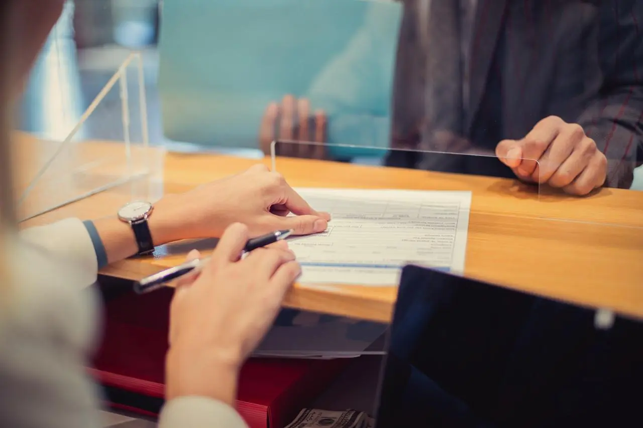 Kobieta składa wniosek o kredyt konsolidacyjny w banku