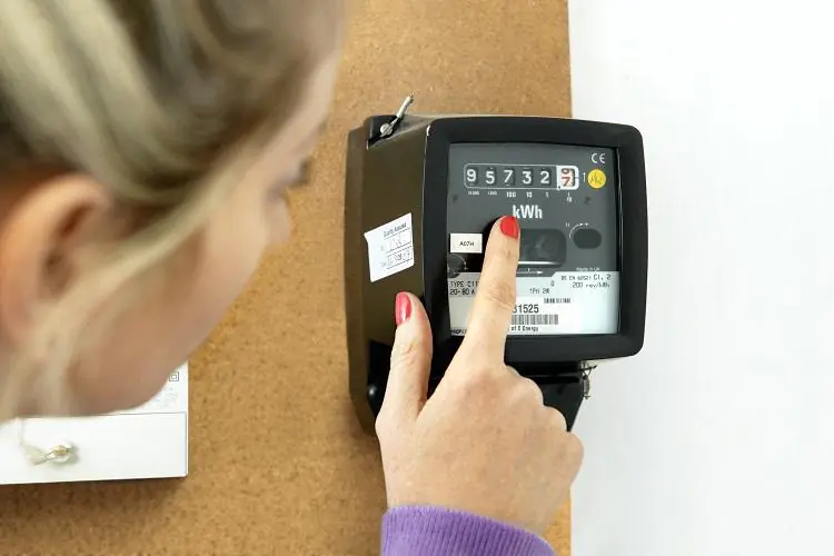 kobieta sprawdzająca licznik energii elektrycznej