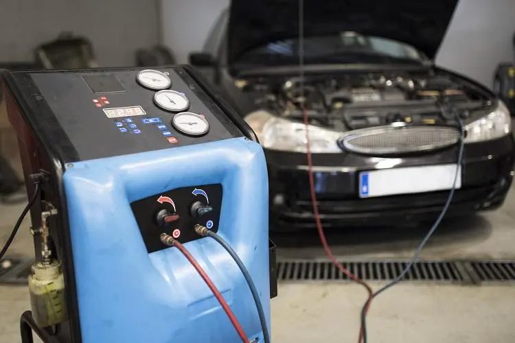 Auto stoi w serwisie podłączone pod urządzenie uzupełniające czynnik klimatyzacji