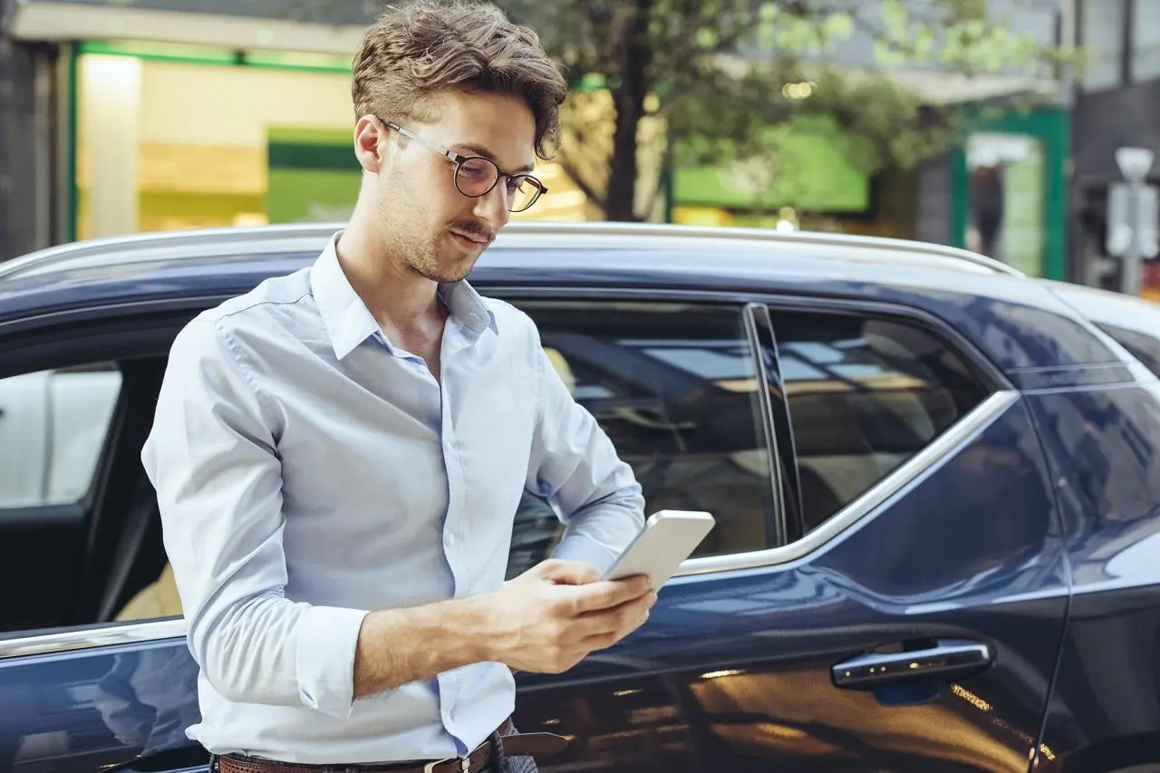 mężczyzna ze smartfonem w dłoni, który sprawdza, jak przenieść aplikację mobilną swojego banku