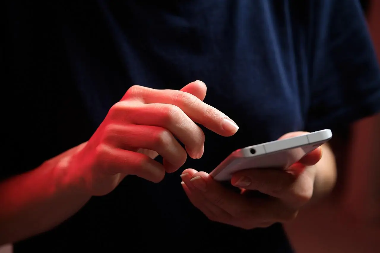 Dziewczyna trzyma w ręku telefon komórkowy