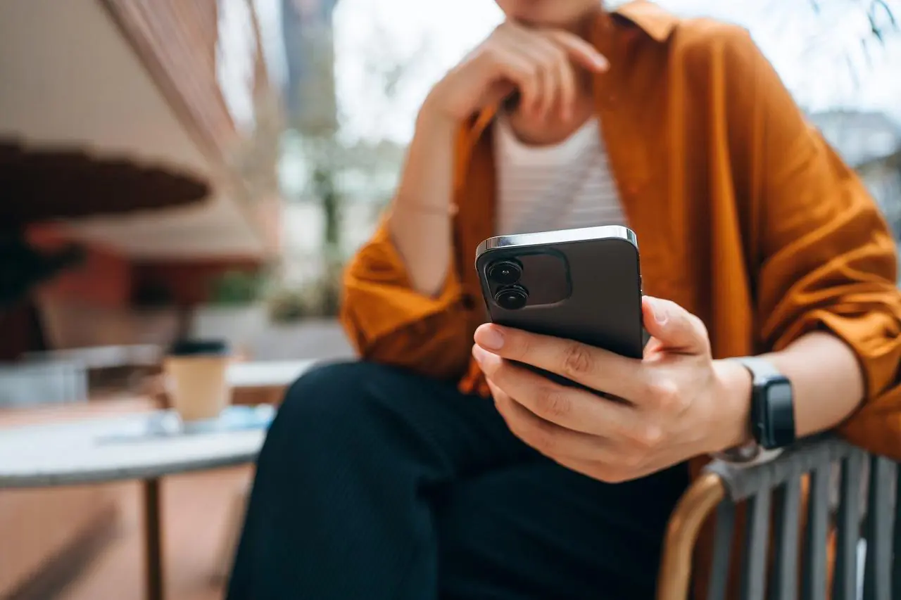 Kobieta trzyma w dłoni telefon komórkowy