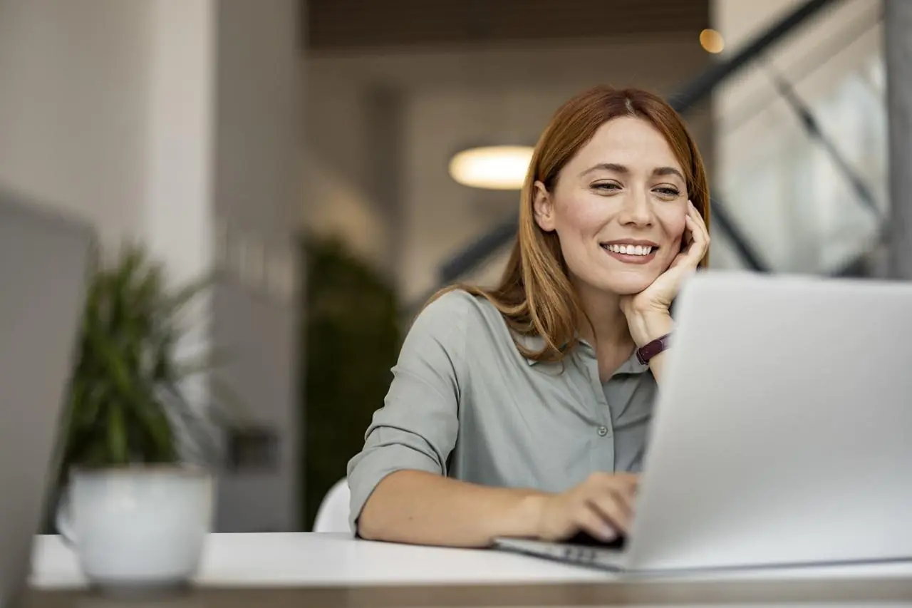 Zadowolona kobieta na laptopie zakłada lokatę na 3 miesiące online