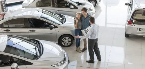 Młodzi ludzie kupują na kredyt samochód w salonie