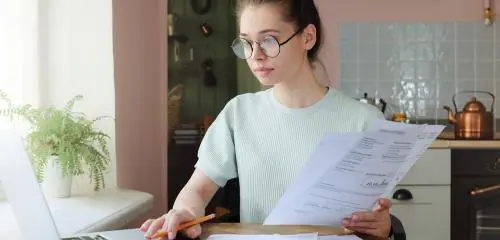 Kobieta przegląda operat szacunkowy nieruchomości otrzymany od rzeczoznawcy