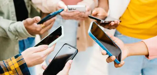 Kilka osób trzyma smartfony i wykonuje przelew na telefon BLIK