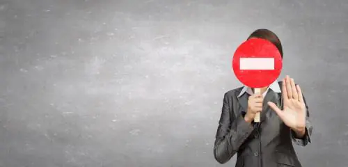 kobieta zasłaniająca twarz znakiem zakaz wjazdu
