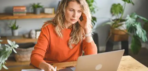 Kobieta przegląda na laptopie raport BIK na swój temat