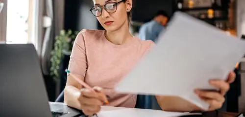 Kobieta wypełnia wniosek o wykreślenie hipoteki z księgi wieczystej