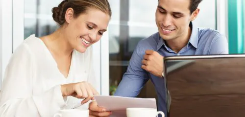 Kobieta w biurze przedstawia mężczyźnie możliwość uzyskania kredytu obrotowego