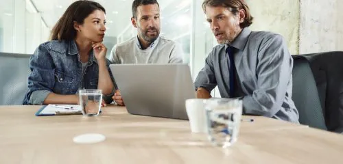 Małżeństwo podczas spotkania w banku. Doradca finansowy przedstawia na laptopie kredyt hipoteczny z oprocentowaniem stałym