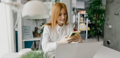Młoda kobieta przy biurku liczy czy opłaca jej się pożyczka hipoteczna