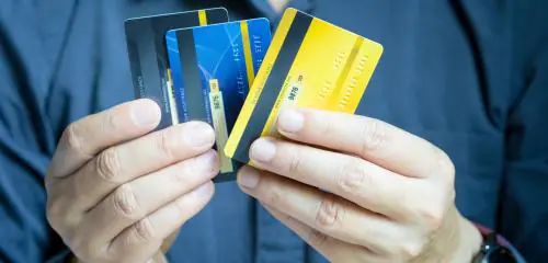 Mężczyzna trzyma w ręku karty przedpłacone, karta prepaid