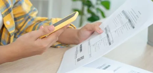 Mężczyzna sprawdza wyciąg rozliczeń transakcji na karcie kredytowej