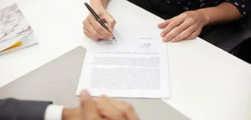 kobieta podpisująca umowę pożyczki w oddziale firmy pozabankowej