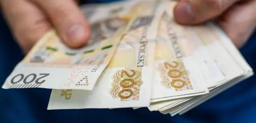 Mężczyzna liczy pieniądze, które może zaoszczędzić wybierają raty równe - annuitetowe lub malejące przy kredycie hipotecznym