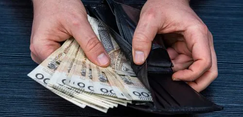 Mężczyzna liczy pieniądze w portfelu, które otrzymał w ramach kredytu 0%