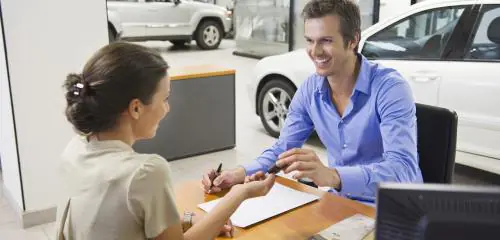 Mężczyzna kupuje w salonie samochód elektryczny