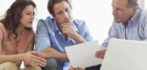 Kobieta i mężczyzna omawiają z doradcą umowę o kredyt konsumencki
