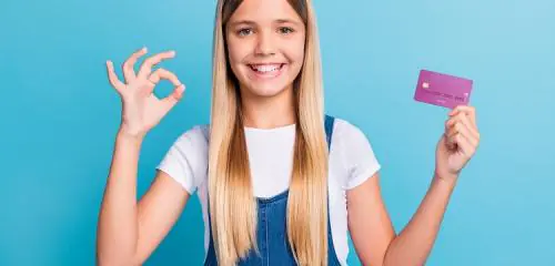 Dziewczynka z kartą płatniczą na niebieskim tle