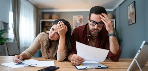 Para młodych ludzi w trakcie rozwodu, czytająca umowy i zastanawiająca się nad podziałem spłaty kredytu gotówkowego