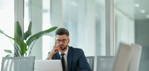 Biznesmen w biurze sprawdzający w laptopie rejestr ERIF.
