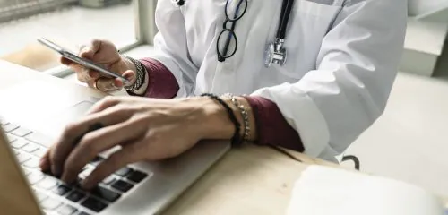 młoda lekarka sprawdzająca na stronie internetowej kredyt na studia medyczne