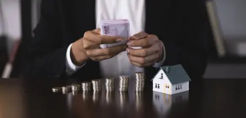 Mężczyzna liczy pieniądze potrzebne do zapłaty zadatku przy kupnie nieruchomosci