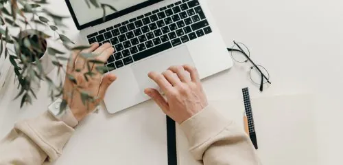 mężczyzna siedzący przy laptopie realizujący przelew przez internet