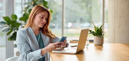 Kobieta siedząca w biurze i zlecająca online przeniesienie konta do innego banku