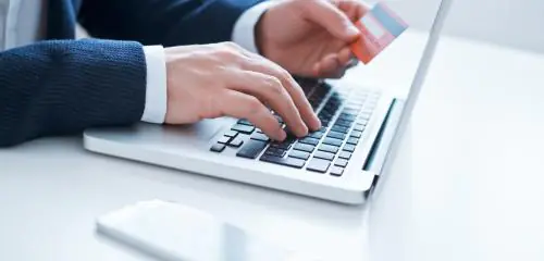Mężczyzna aktywuje kartę Banku Millennium przez bankowość internetową
