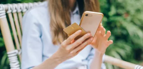 złota karta, kobieta trzyma złotą kartę kredytową