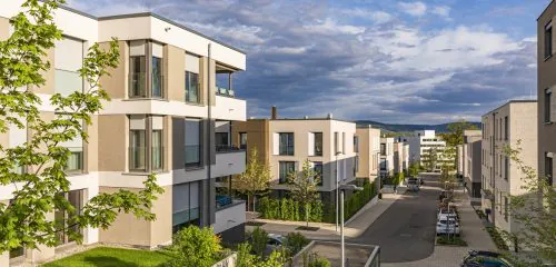 Osiedle mieszkaniowe wynajmowane w ramach TBS na tle zachmurzonego nieba