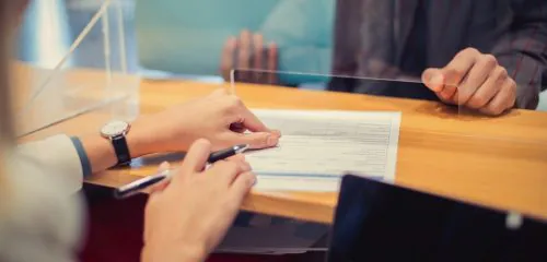 Kobieta składa wniosek o kredyt konsolidacyjny w banku