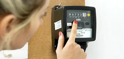 kobieta sprawdzająca licznik energii elektrycznej