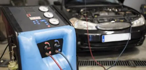 Auto stoi w serwisie podłączone pod urządzenie uzupełniające czynnik klimatyzacji