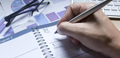 Doradca finansowy zapisuje w kalendarzu termin spotkania